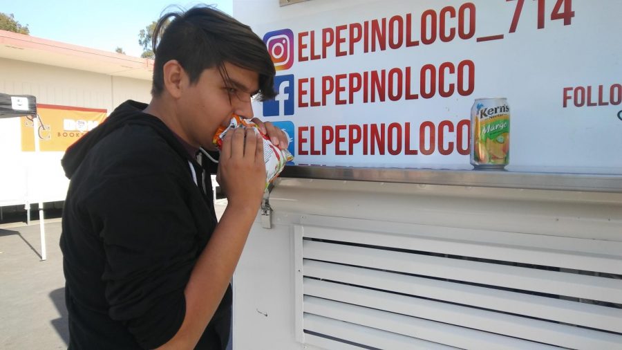 Eduardo Velazquez enjoys a nice bag of Hot Cheetos, while waiting for an esquite at El Pepino Loco.
