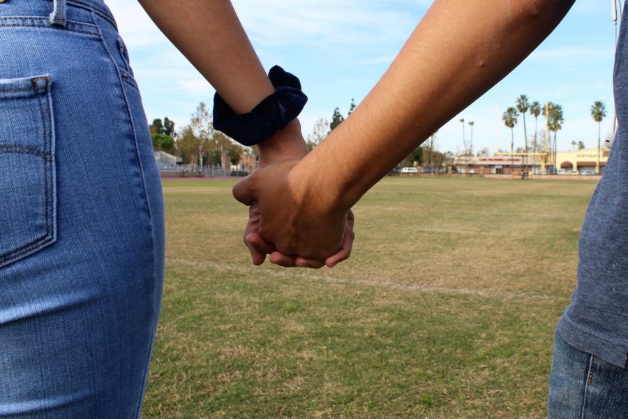 A couple holds hands.
