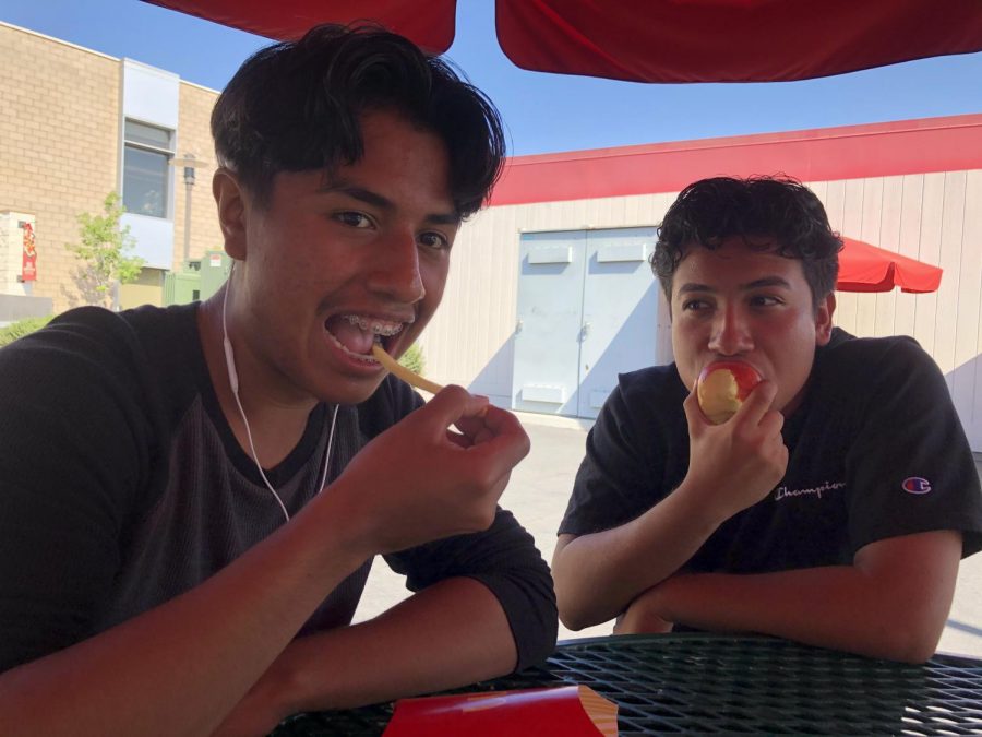 Senior Andres Reyes consumes McDonalds fries while Senior Alan Cuevas eats an apple to maintain his healthy habits