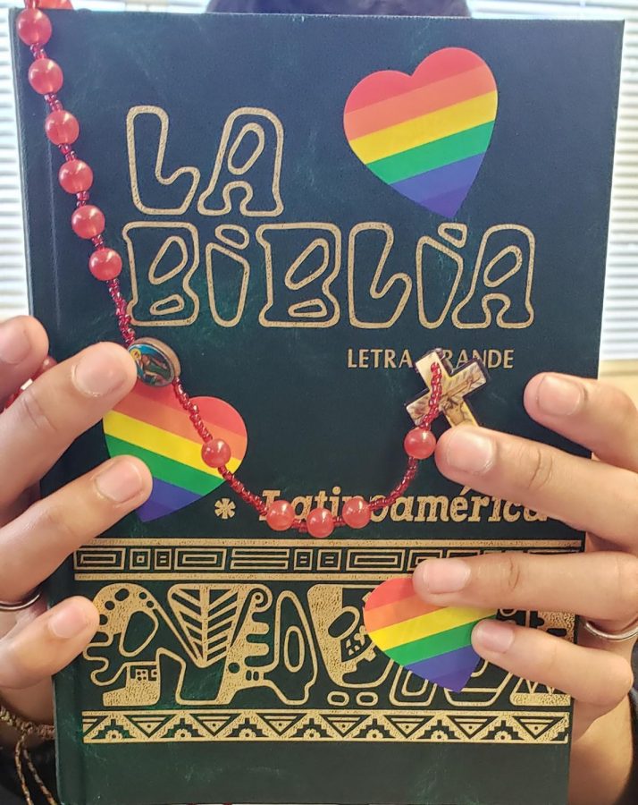 A student holds a Bible while also  expressing his pride and support for the LGBTQ+ community.