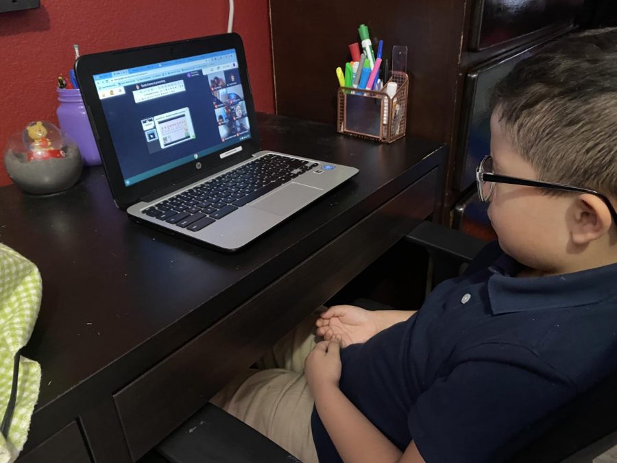 A second grade elementary student attends an online Zoom class.