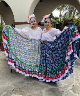 Cecilia Jáurejul (left) and Ema Lopez (right) from the Relámpago del Cielo dance group get ready to perform their folkloric dance at Bowers Museum on Sunday Oct. 24, 2021 for the Día de los Muertos festival.