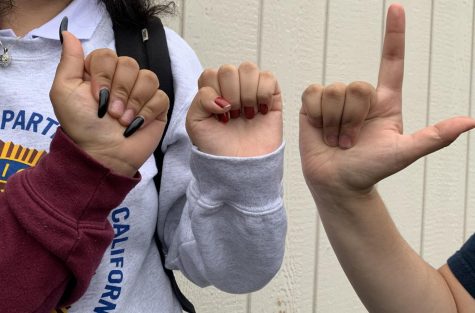 Students at Middle College High School show their progress with American Sign Language.