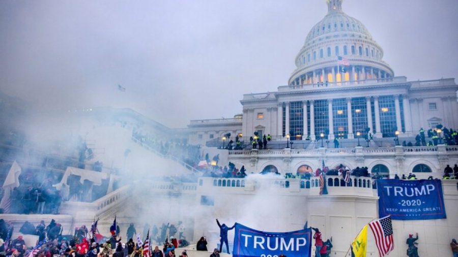 Trump supporters riot outside the capitol building as tear gas is being thrown at them on January 6, 2021.