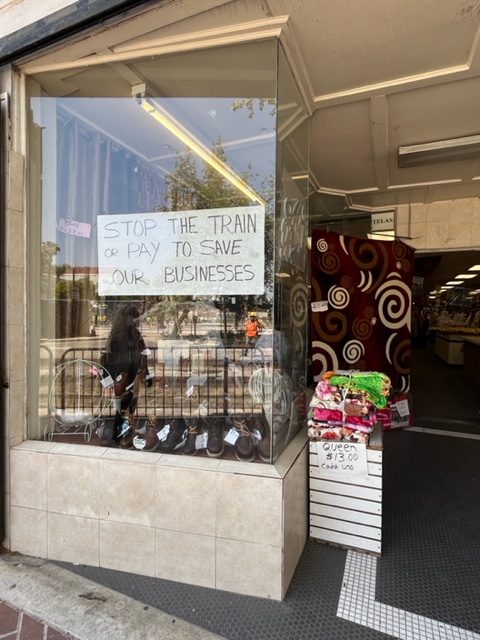 Shop windows now hang signs pleading for help during the construction of the new OCTA streetcar.