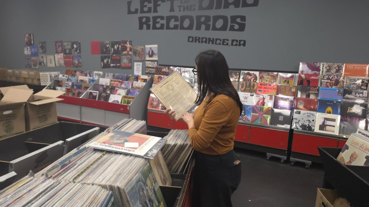 A patron of Left Of The Dial Records browses through old vinyl records to listen to later.